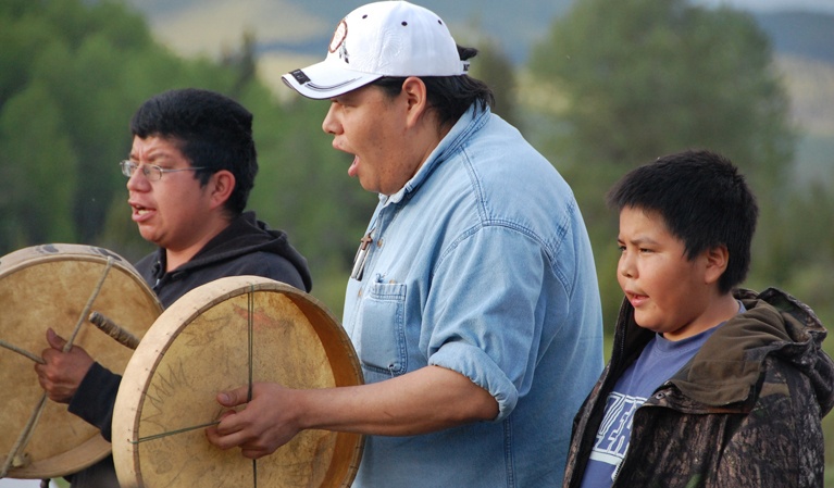 Drummers two men and young boy singing outside